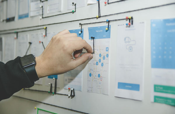 Person pinning documents on a planning board